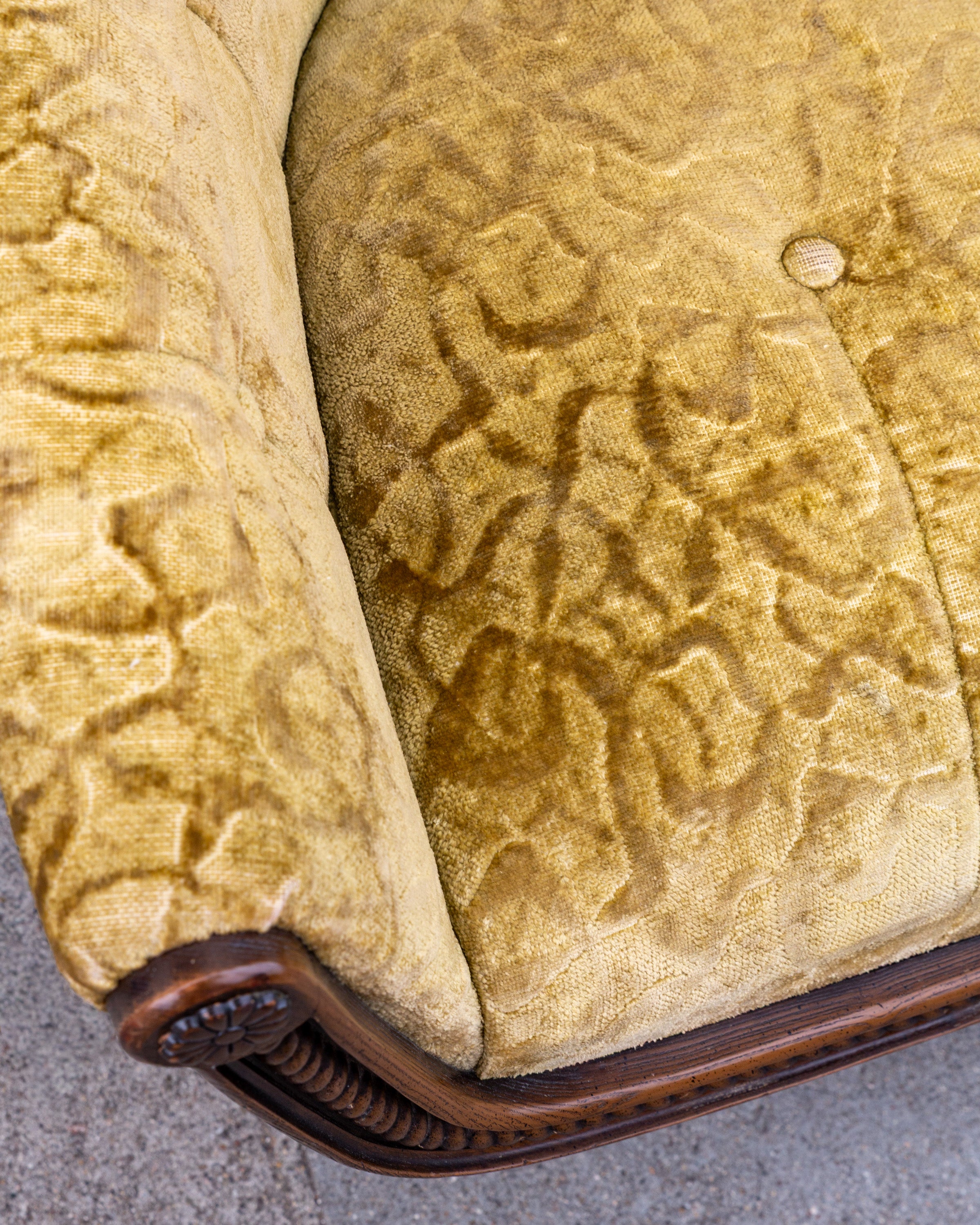 Detail of the seat and back junction in gold velvet, showing one button that has lost its velvet cover