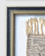 Close view of the upper left frame corner, black with gold beaded edges, on a light gray background.