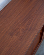 Detail of the teak veneer grain across the top of a mid century credenza