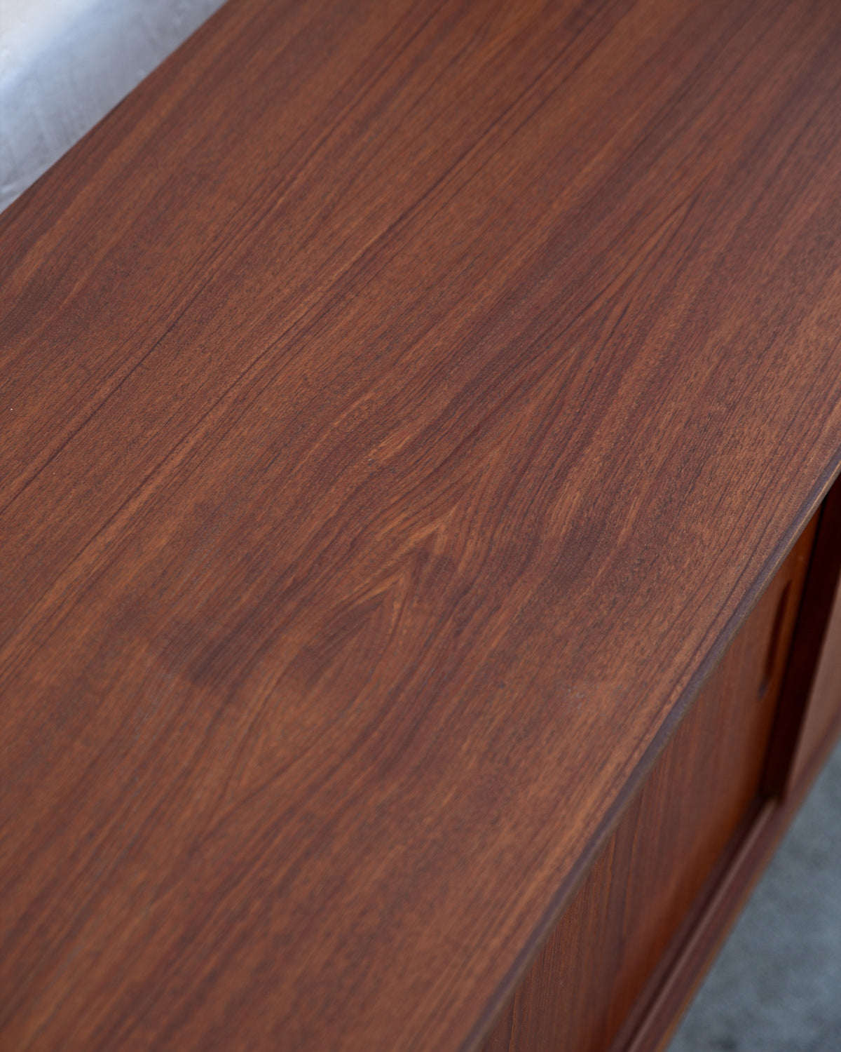 Detail of the teak veneer grain across the top of a mid century credenza